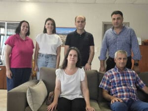 :Στην φωτογραφία απεικονίζονται καθισμένοι στον καναπέ η Πρόεδρος της Περιφερειακής και ο Γενικός Γραμματέας και πισω,όρθιοι,απο αριστερά προς τα δεξιά η Ειδική Γραμματέας της Περιφερειακής,η Αντιδήμαρχος Οικονομικών,ο Δήμαρχος Αρταίων και ο Αντιδήμαρχος Κοινωνικής Μέριμνας