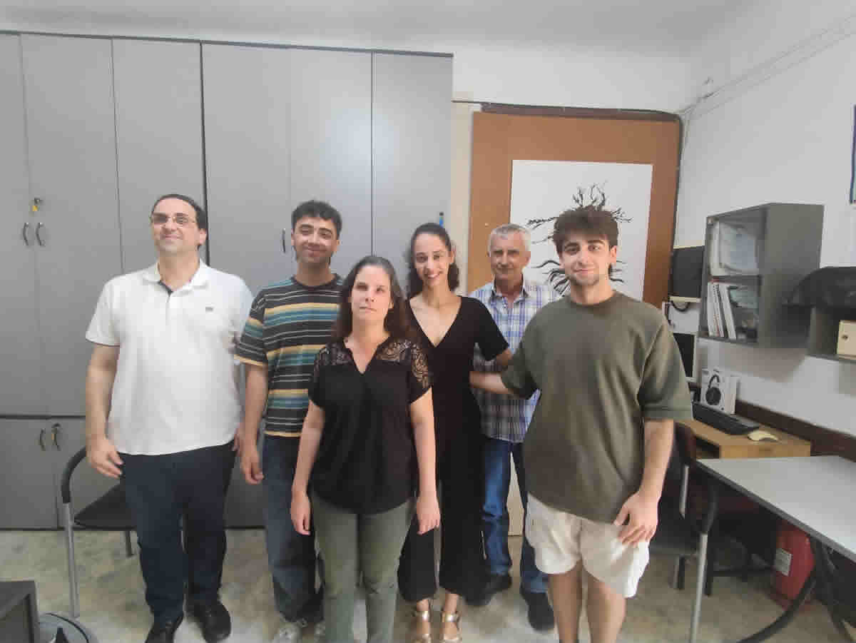 : Στην φωτογραφία απεικονίζονται όρθιοι,στο χώρο του γραφείου της Περιφερειακής τα μέλη της ομάδας iGEM μαζί με την Πρόεδρο,τον Γενικό Γραμματέα και ενα μέλος της Περιφερειακής